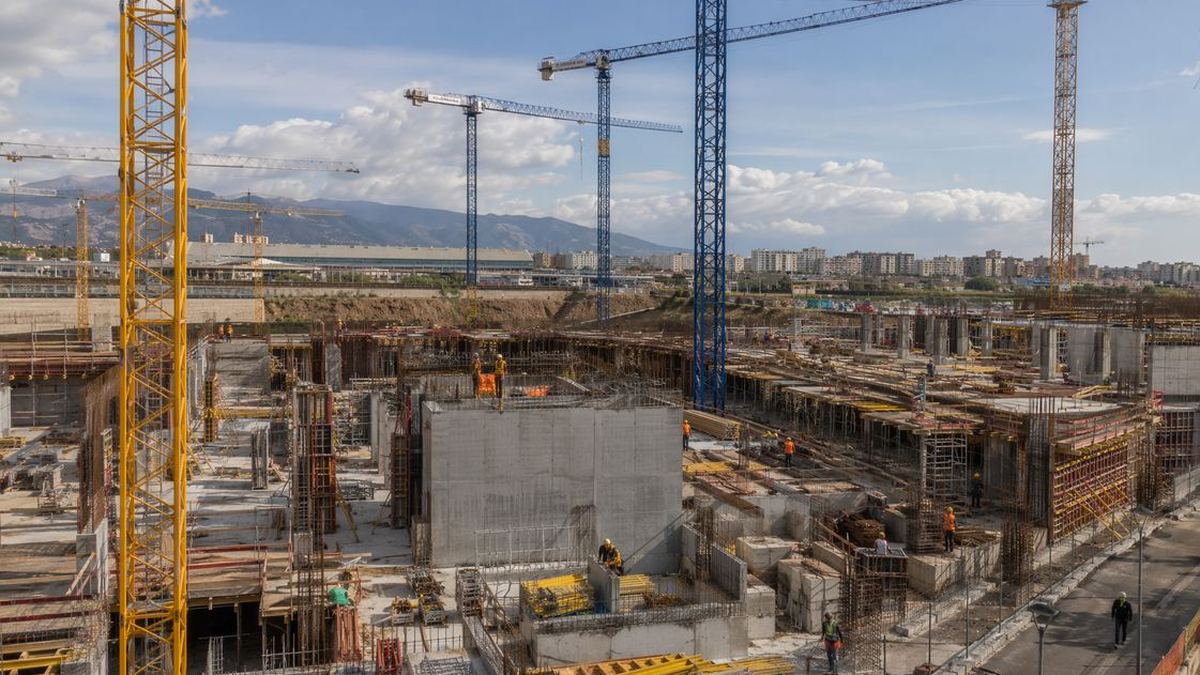 Grande cantiere italiano con gru a torre e operai al lavoro